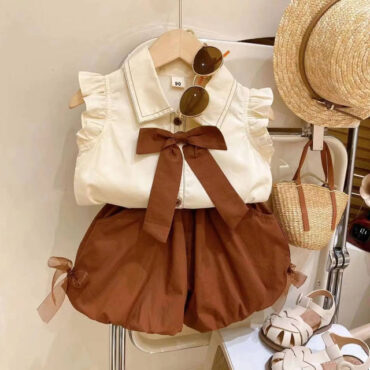 ⁦طقم بناتي أنيق مكون من شميز بدون أكمام مزين بفيونكة وشورت بتصميم عصري جذاب⁩ - الصورة ⁦2⁩